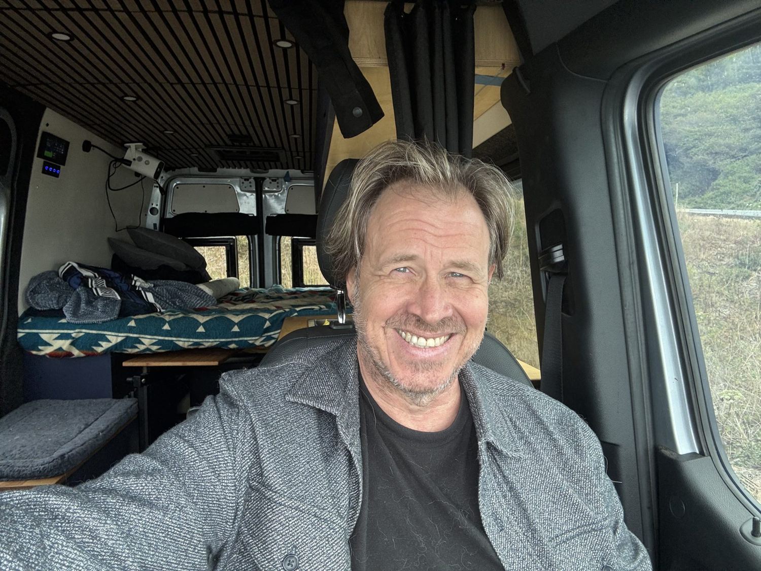 Matt smiling in the driver's seat of the van